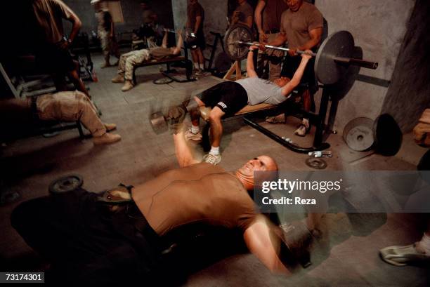 The captain Tommy Cardonne, chief of the US military base of Shkin, holds weight in the weights room on July, 2004 in Afghanistan.