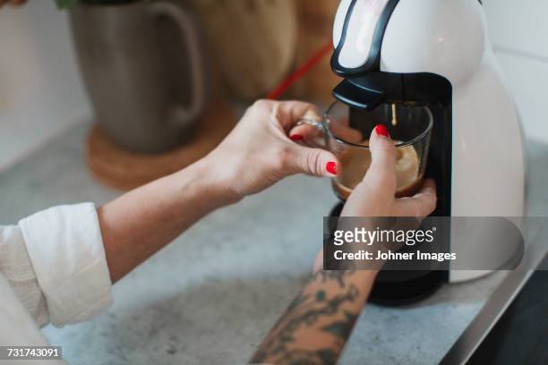 young woman making coffee - kaffeemaschine stock-fotos und bilder