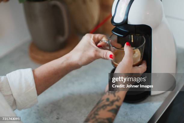 young woman making coffee - koffiemachine stockfoto's en -beelden