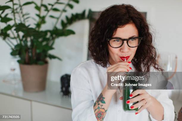 young woman drinking smoothie - drinking juice stock-fotos und bilder