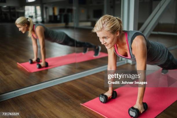 woman exercising in gym - flexiones fotografías e imágenes de stock