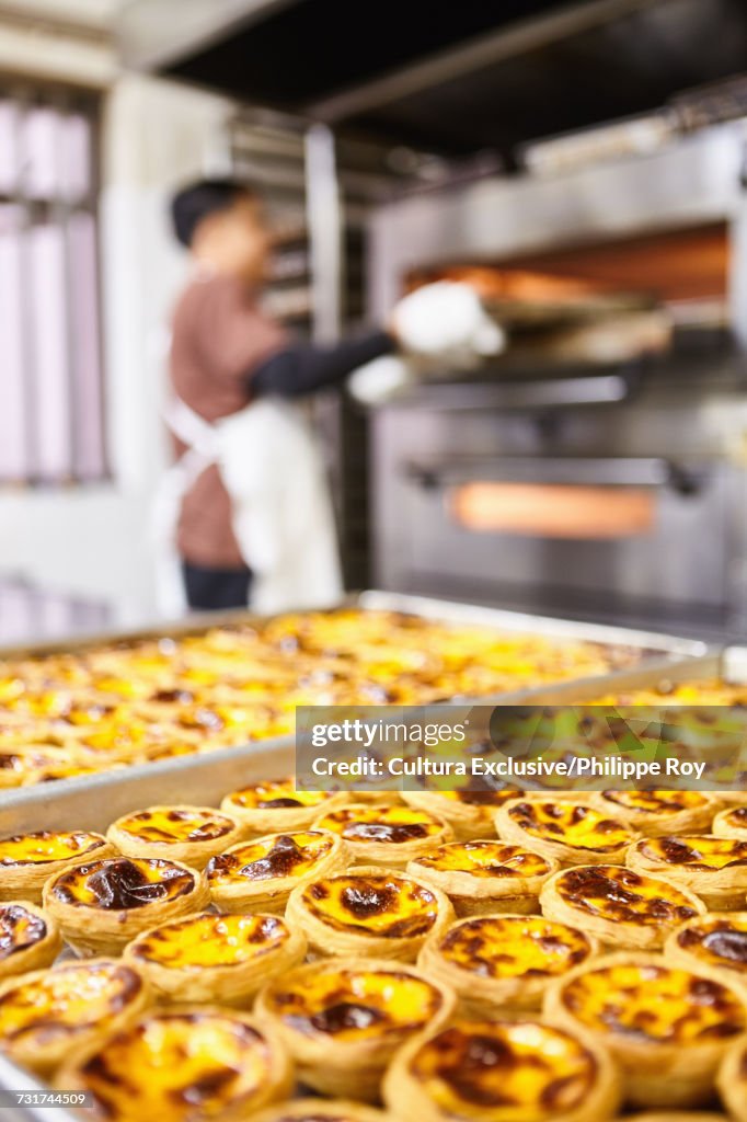 Trays of traditional egg tarts on food stall, Macau