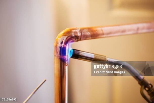 close up of a copper pipe being welded. - welding torch stock pictures, royalty-free photos & images