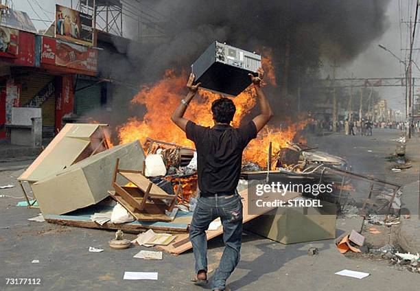 Protestor from the Mahdheshi community throws office equipment onto a blazing barricade in Birgunj, in the Parsa district, some 276 kms south of...