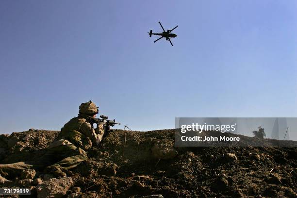 An American Apache helicopter proves air support as a U.S. Marine takes aim after being fired upon by insurgents near the Euphrates River February 2,...