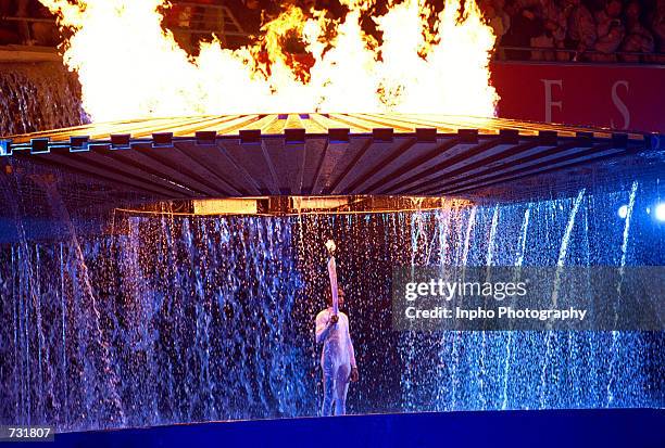 The cauldron containing the Olympic flame rises above Aboriginal Australian torch bearer Cathy Freeman September 15, 2000 during the opening ceremony...