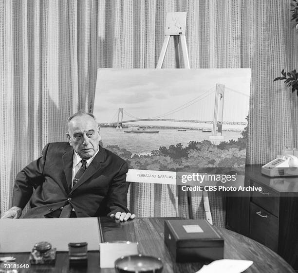 American public official and city planner Robert Moses sits next to an illustration of the Verrazano Narrows Bridge during an interview for the 'Eye...