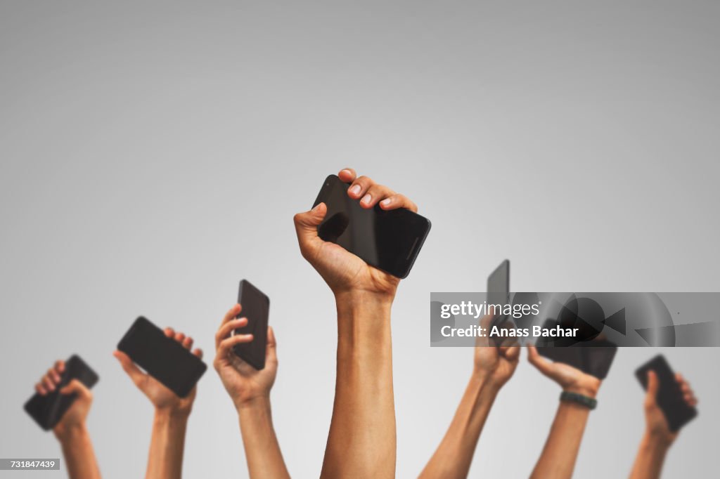 Low Angle View Of Hands Holding Mobile Phone Against White Background