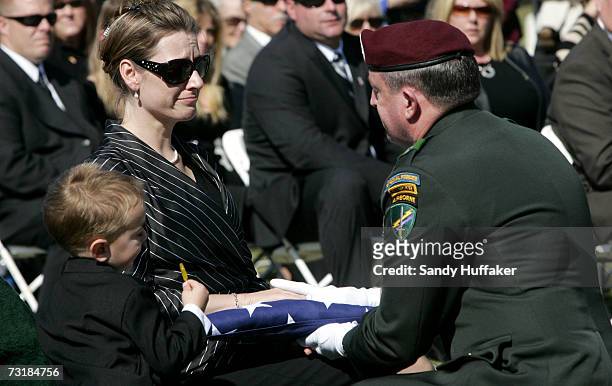 General David Morris hands Charlotte Freeman a flag from her husband's coffin during a memorial service at Ft. Rosecrans National Cemetery on...
