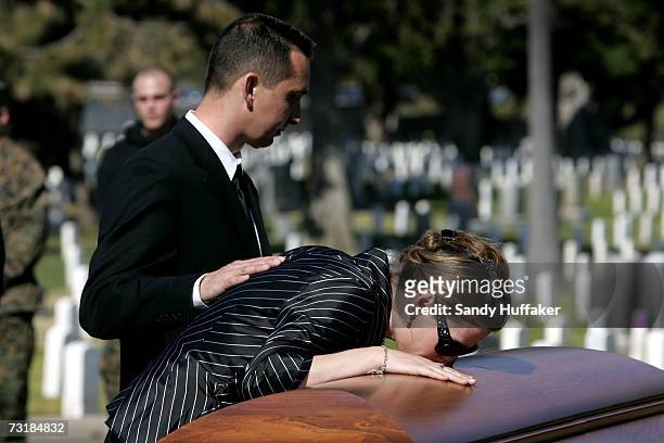 Charlotte Freeman touches the coffin of her husband Capt. Brian Freeman during a memorial service at Ft. Rosecrans National Cemetery on February 2,...