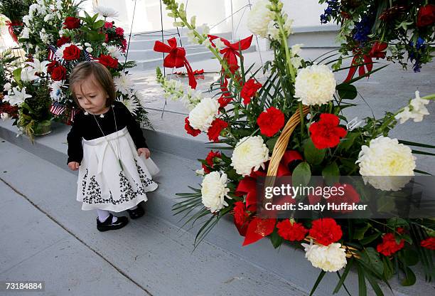 Ingrid Freeman months looks over a display of flowers at the funeral of her father Captain Brian Freeman during a memorial service at Ft. Rosecrans...