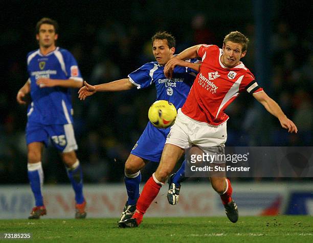 Cardiff City striker Michael Chopra is challengd by Paul Reid of Barnsley during the Coca Cola Championship game between Cardiff City and Barnsley at...