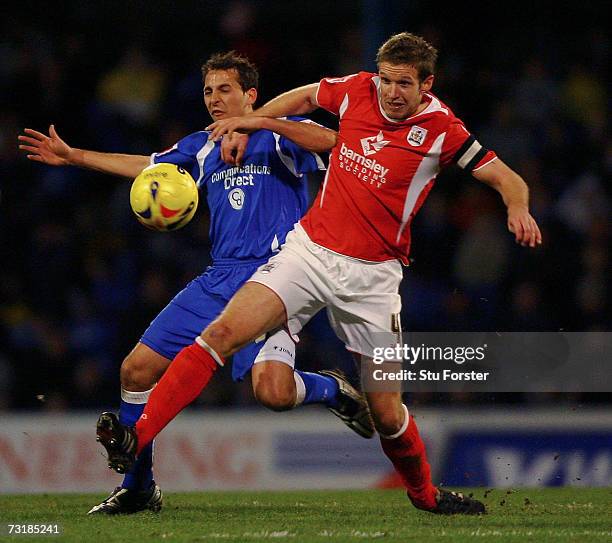 Cardiff City striker Michael Chopra is challengd by Paul Reid of Barnsley during the Coca Cola Championship game between Cardiff City and Barnsley at...