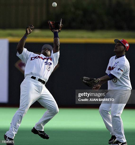 San Juan, PUERTO RICO: Miguel Tejada atrapa una pelota frente a su companero Tony Pena de Aguilas Cibaenas de Republica Dominicana, antes un juego...