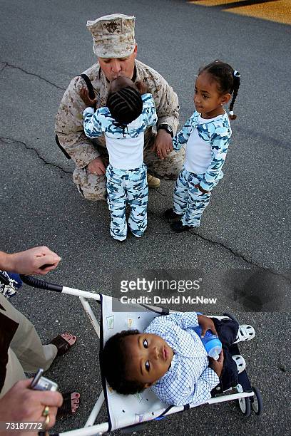 Chief Warrant Officer Gary Walker gets a kiss from his three-year-old daughter Angel while Eliana, also three years old, waits her turn and Isaiah,...