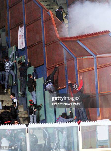 Fans try to scale the fence as they turn on each other and police officers during the Serie A match between Palermo and Catania Calcio at Stadio...