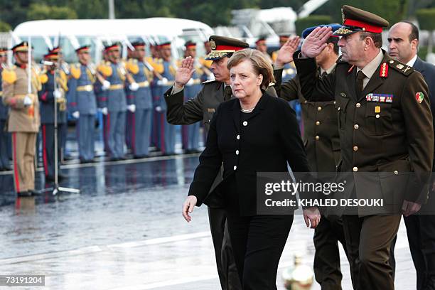 German Chancellor Angela Merkel reviews the honor guard during a visit to the tomb of late Egyptian president Anwar Sadat in Cairo 03 February 2007....