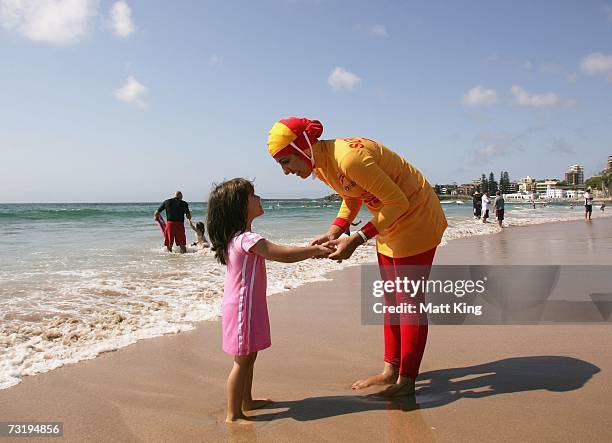 Mecca Laa Laa talks to a young girl whilst wearing a 'Burqini' on her first surf lifesaving patrol at North Cronulla Beach February 4, 2007 in...