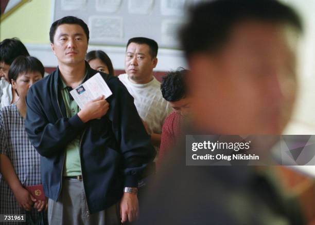 Chinese citizens go through the passport control in the village of Pogranichny, 250 km South-East of Vladivostok, in the Russian Far East, August 30,...