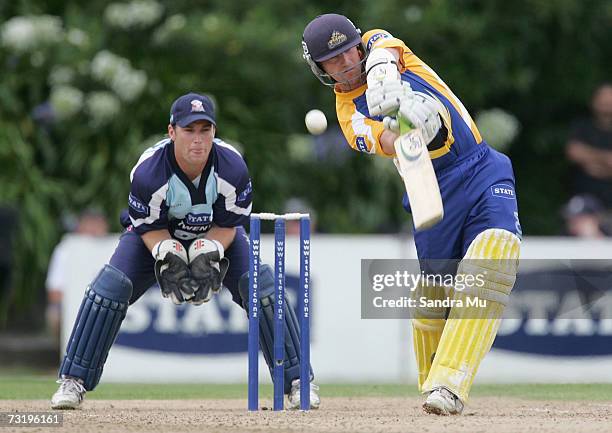 Gareth Hopkins of Otago hits the ball while Wicketkeeper Reece Young of Auckland watches on during the Twenty20 Final match between State Auckland...