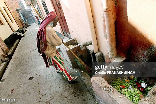 In this photo taken, 15 January 2007, Chandrawati, sweeper and drain cleaner by profession, cleans out a drain in the Shahdara area of eastern New...