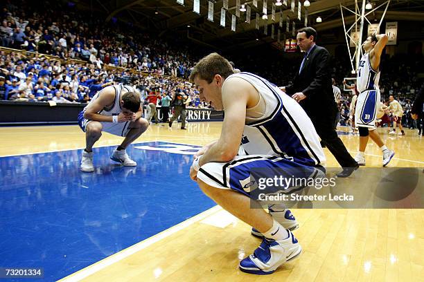 Head coach Mike Krzyzewski of the Duke Blue Devils checks on teammates Josh McRoberts and Greg Paulus after being defeated by the Florida State...