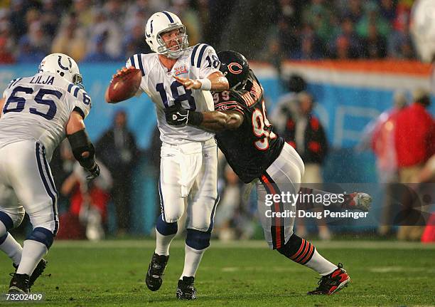 Quarterback Peyton Manning of the Indianapolis Colts scrambles to throw a touchdown under pressure from defensive tackle Tank Johnson of the Chicago...