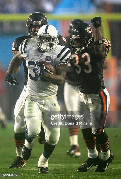 Running back Dominic Rhodes of the Indianapolis Colts runs past Charles Tillman and Hunter Hillenmeyer of the Chicago Bears on a 36-yard carry in the...