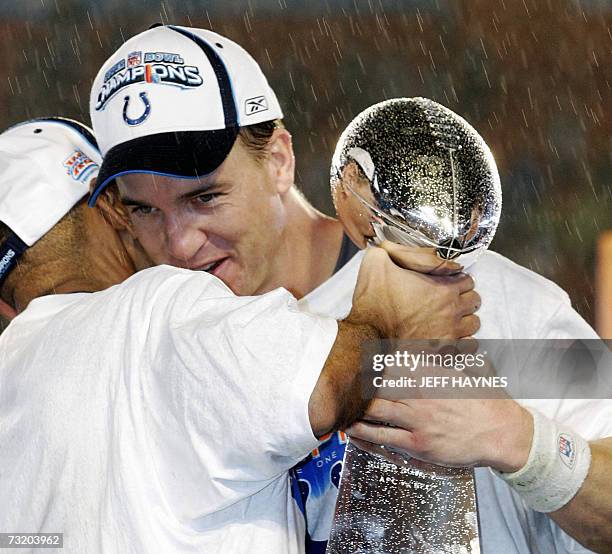 With the rain pouring down, Indianapolis Colts head coach Tony Dungy gets a hug from his quarterback Peyton Manning as they hold the Vince Lombardi...