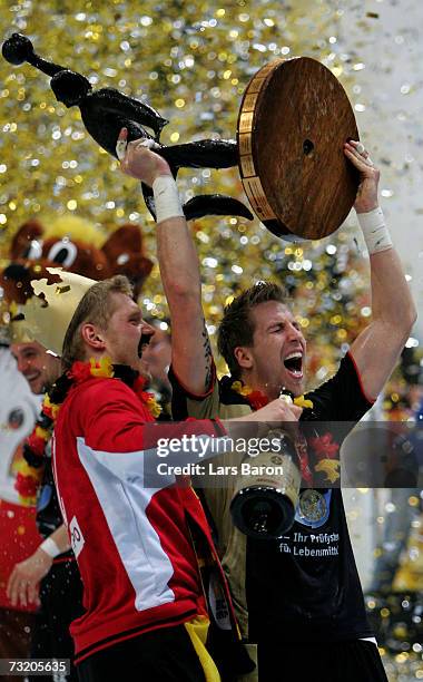 Johannes Bitter and Oliver Roggisch lift the caup after winning the IHF World Championship final game between Germany and Poland at the Cologne Arena...