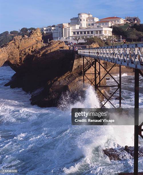 france, biarritz, waves breaking on rocks by sea museum - biarritz stock-fotos und bilder