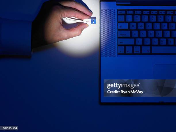 man plugging wire into laptop, close up of hand, overhead view - pen drive - fotografias e filmes do acervo