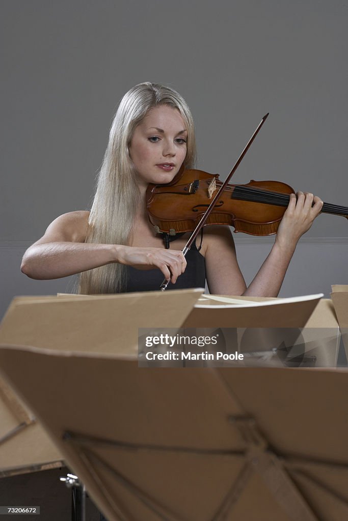 Woman playing violin with sheet music