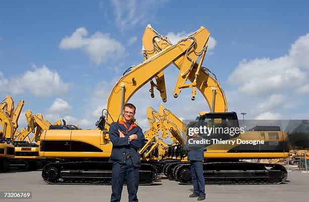 two men standing by excavator - baumaschine stock-fotos und bilder