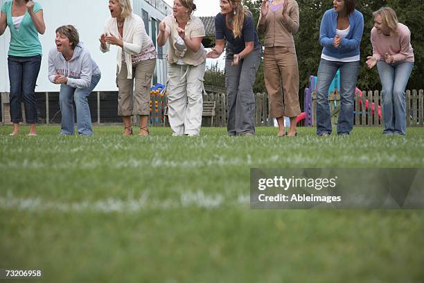 women cheering on sidelines of football field - parents cheering stock pictures, royalty-free photos & images