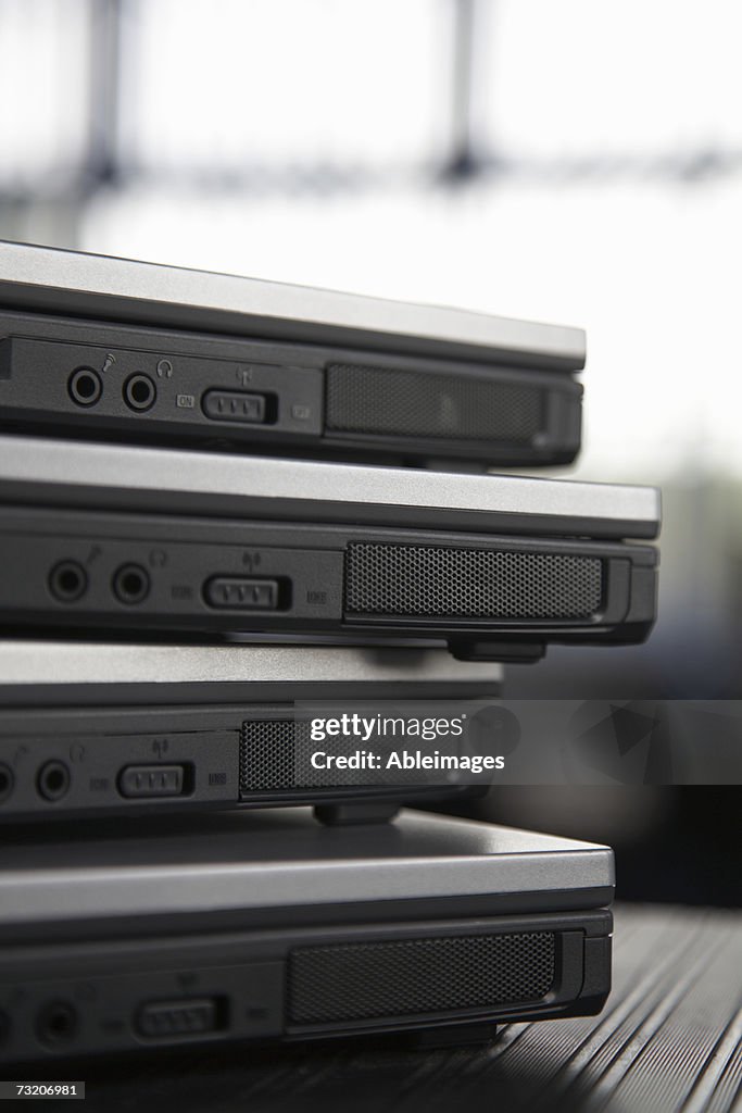 Closed laptops in a stack, close up, rear view