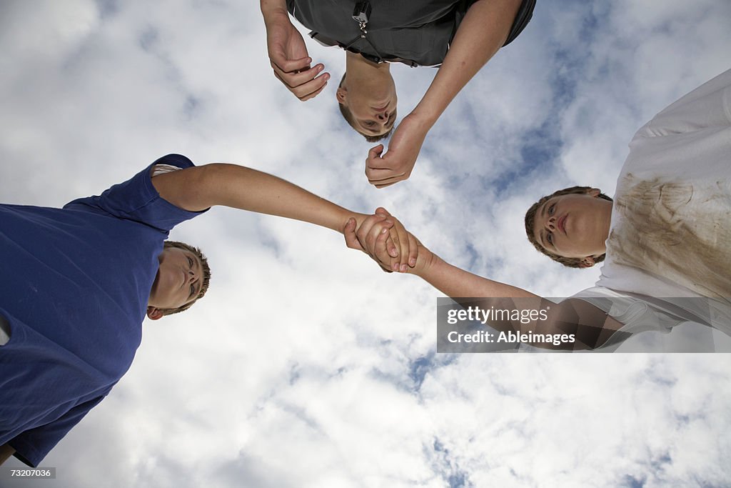 Boys (9-11) shaking hands after soccer game, view from below