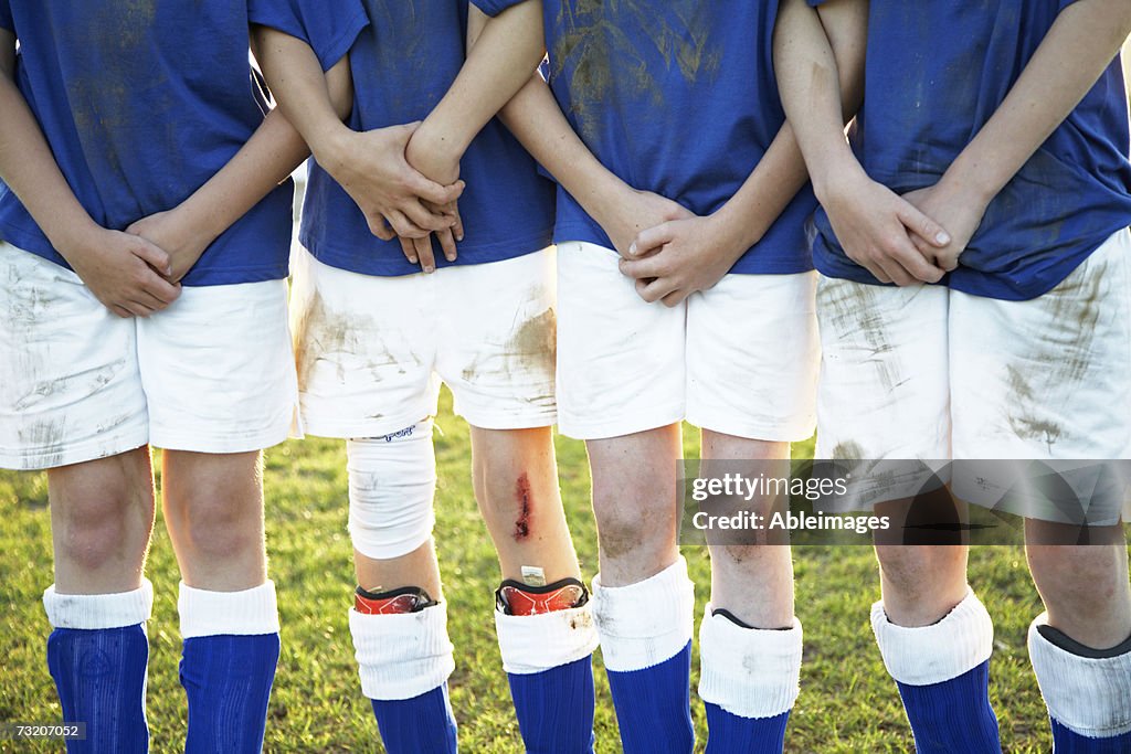 Boys (9-11) standing on soccer team, mid section