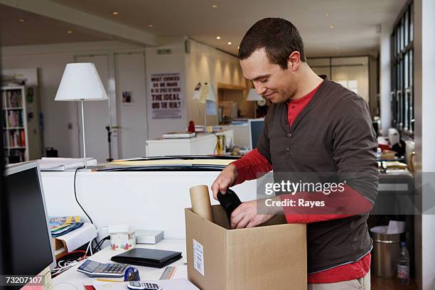 man with cardboard box in office - packing boxes stockfoto's en -beelden