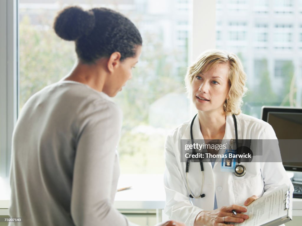 Female doctor and patient talking in exam room