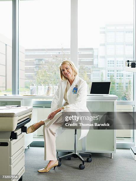 female doctor posing in exam room - woman stool stock pictures, royalty-free photos & images