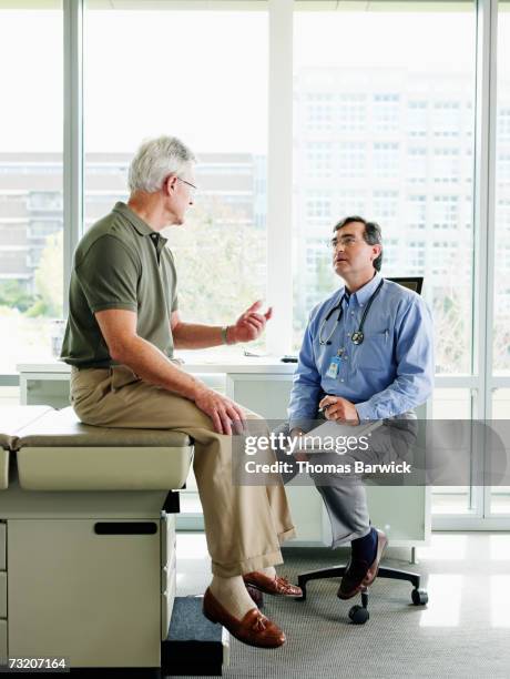 male doctor and patient in exam room - doctor stethoscope patient whole body stock pictures, royalty-free photos & images