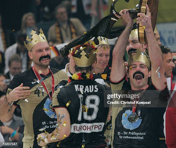 Christian Schwarzer, Michael Kraus and Florian Kehrmann celebrate their victory over Poland after the IHF World Championship final between Germany...