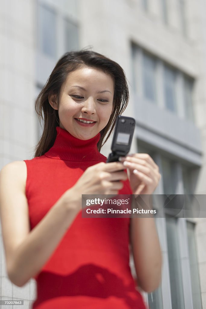 Young woman using mobile phone in street