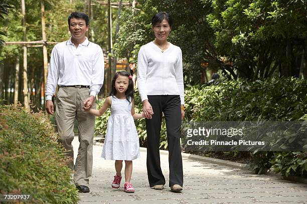 parents walking with daughter (4-5) in park, portrait - 45 49 år bildbanksfoton och bilder