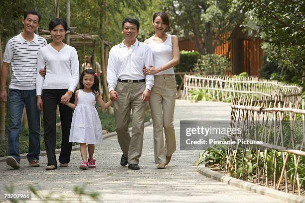 three generation family with girl (4-5) walking in park - 45 49 år bildbanksfoton och bilder