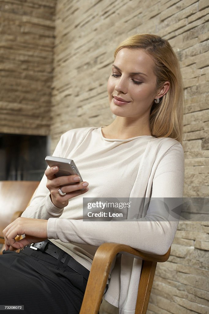 Young woman using palmtop indoors