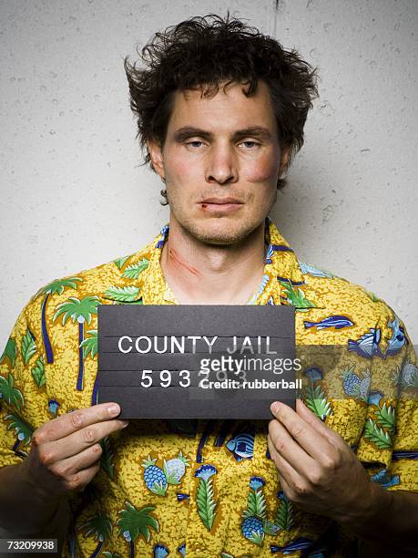 mug shot of man in hawaiian shirt with cuts and scrapes - verbrecherfoto stock-fotos und bilder