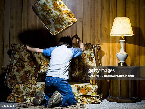 boy searching under sofa cushions - searching mess stock pictures, royalty-free photos & images