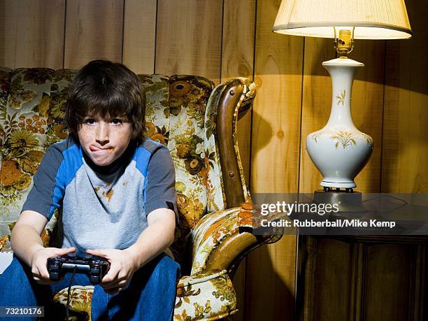 boy with video game controller on sofa - human tongue foto e immagini stock